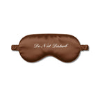 Brown silk sleep mask with 'Do Not Disturb' text for uninterrupted rest and relaxation.