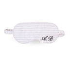 Striped silk sleep mask with personalized embroidery, perfect for comfortable rest and relaxation.