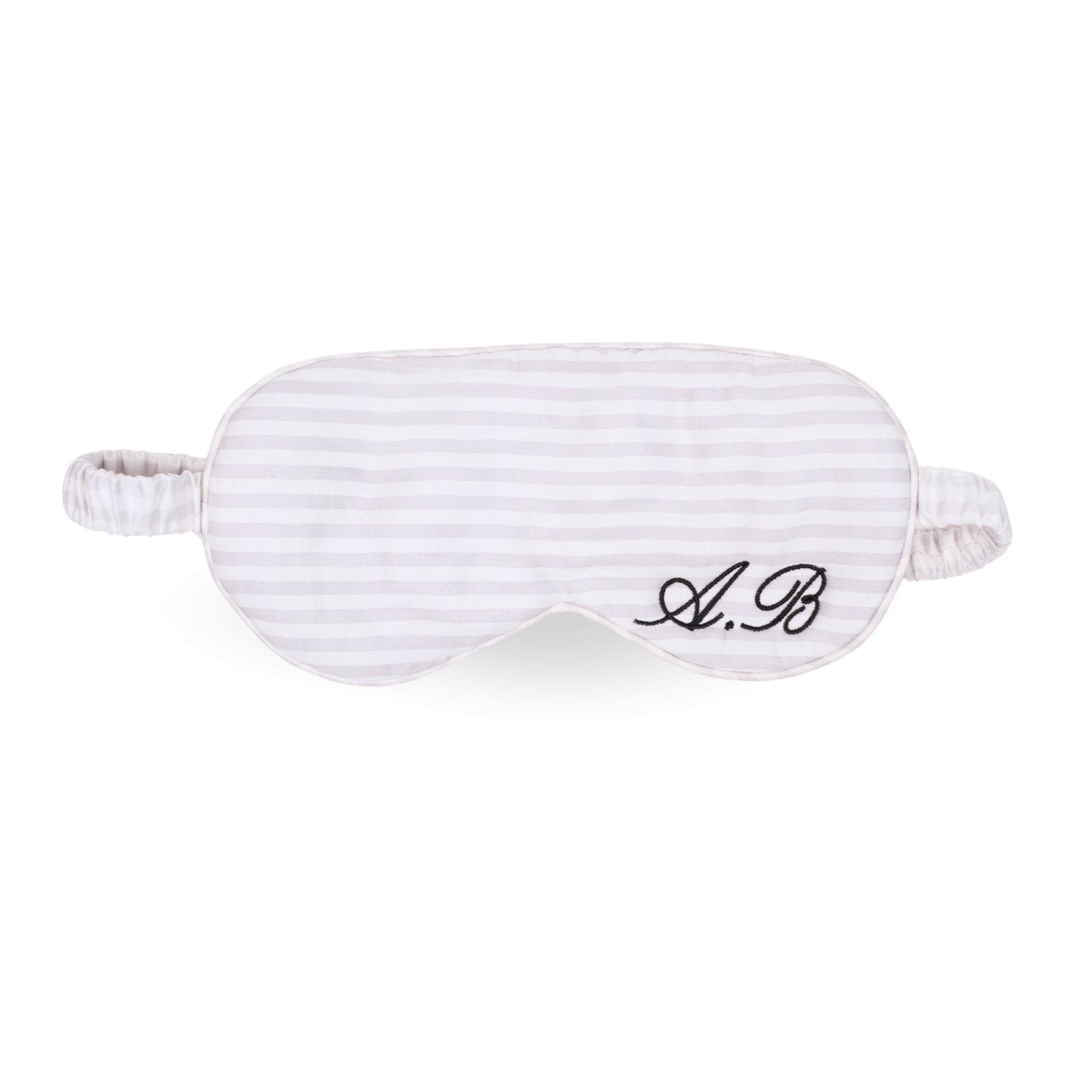 Striped silk sleep mask with personalized embroidery, perfect for comfortable rest and relaxation.