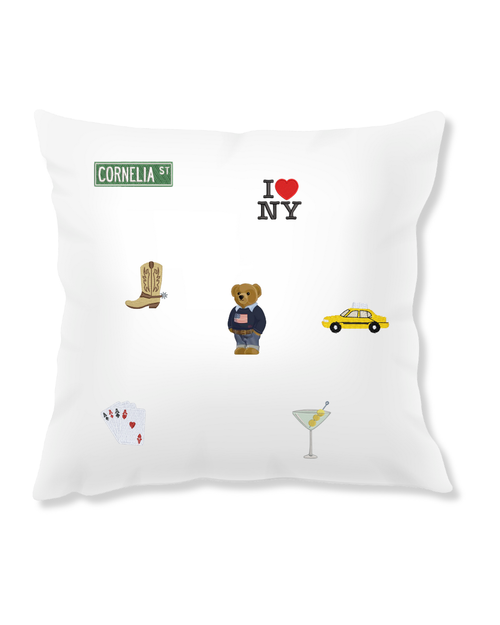 White decorative pillow featuring NYC icons: bear, taxi, cocktail, boots, and playing cards.