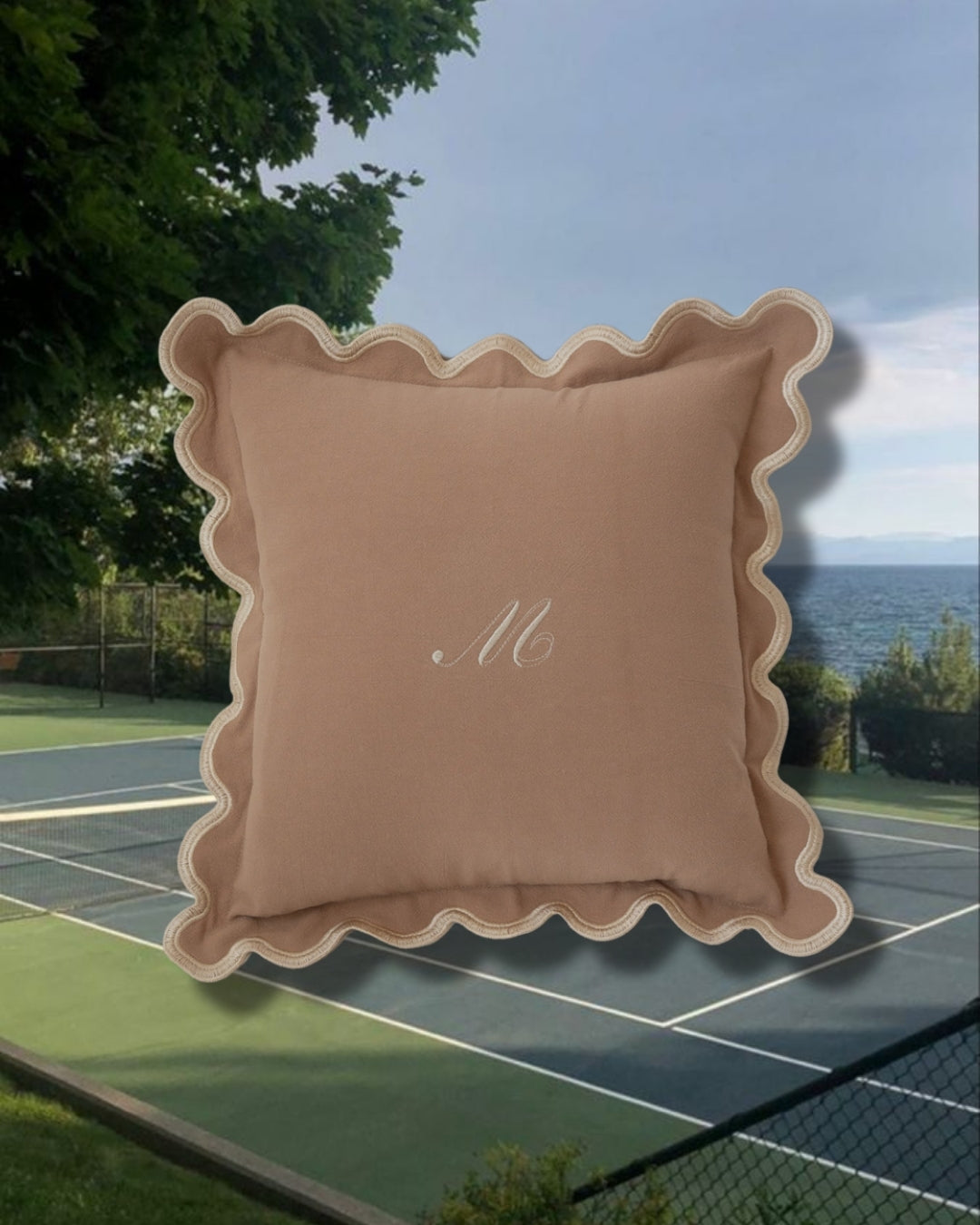 Beige scalloped decorative pillow with embroidered letter M, ideal for stylish home decor.