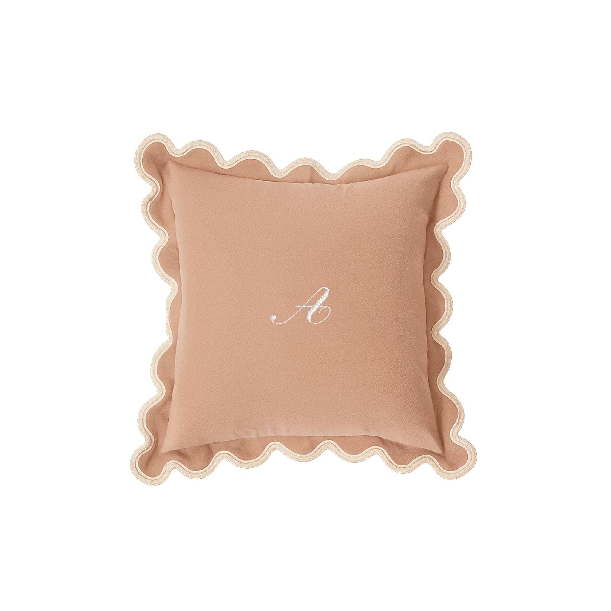 Personalized blush pink pillow with scalloped edges and embroidered 'A' monogram.
