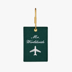 Green luggage tag with 'Mr. Worldwide' embroidery and airplane design, perfect for stylish travel.