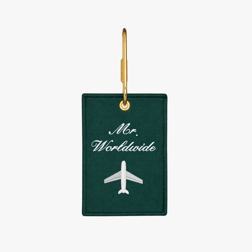 Green luggage tag with 'Mr. Worldwide' embroidery and airplane design, perfect for stylish travel.