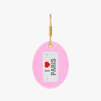 Fun pink keychain with 'I Love Paris' design, featuring a gold-tone hook and soft fabric material.