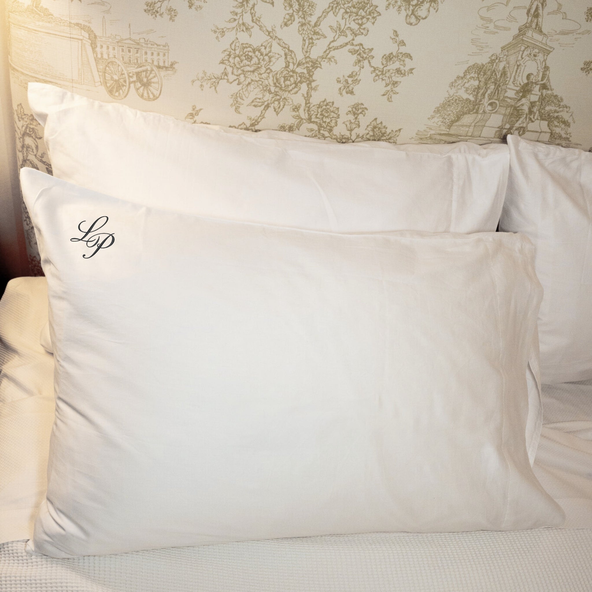Luxury white king-size pillow with monogram 'LP', perfect for elegant bedding.