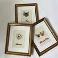 Personalized pet portraits in gold frames, featuring a cat, dog, and two dogs, intricate embroidery on fabric.