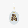 Embroidered oval keychain with a stylish 'A' in tiger stripes, featuring a gold clasp.