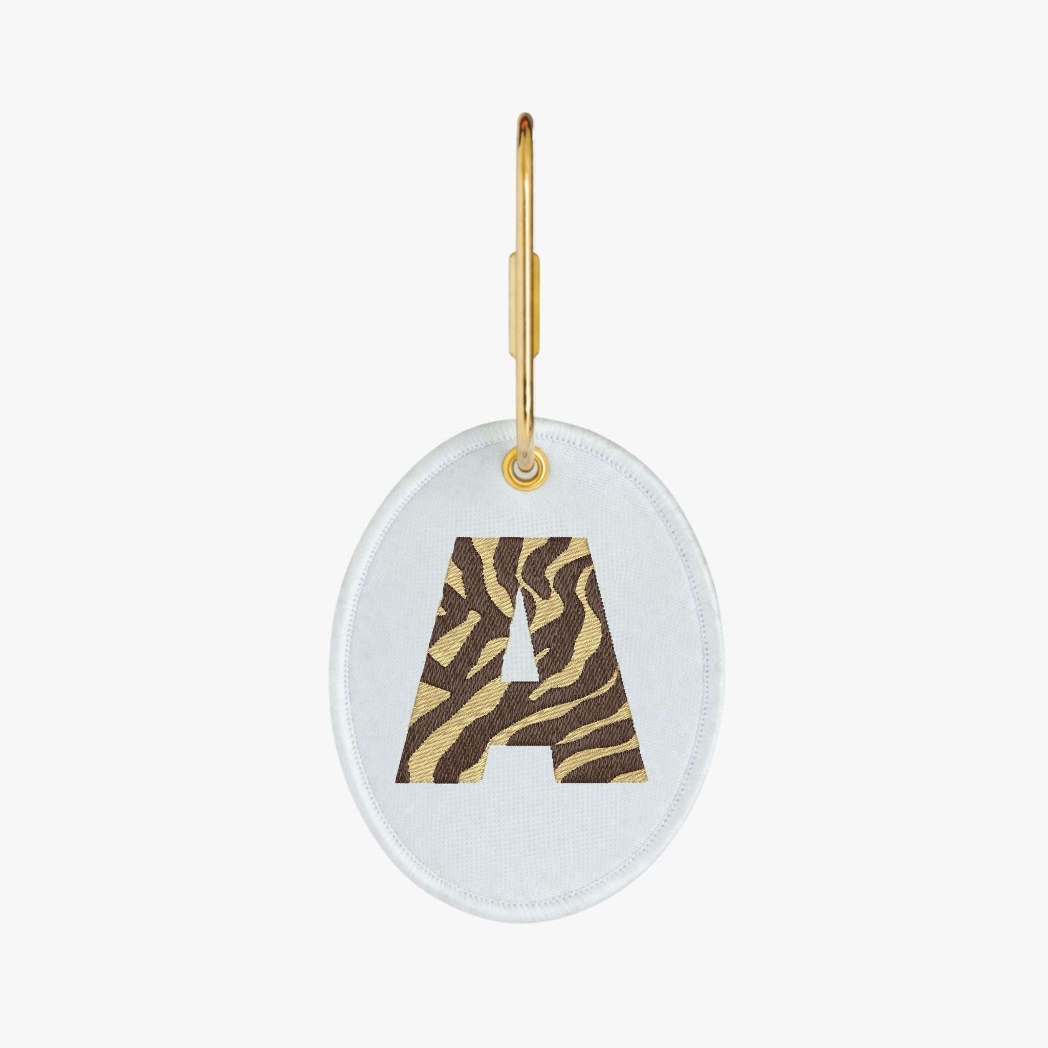 Embroidered oval keychain with a stylish 'A' in tiger stripes, featuring a gold clasp.