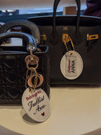 Two designer handbags with personalized name tags, one black quilted, one black leather.