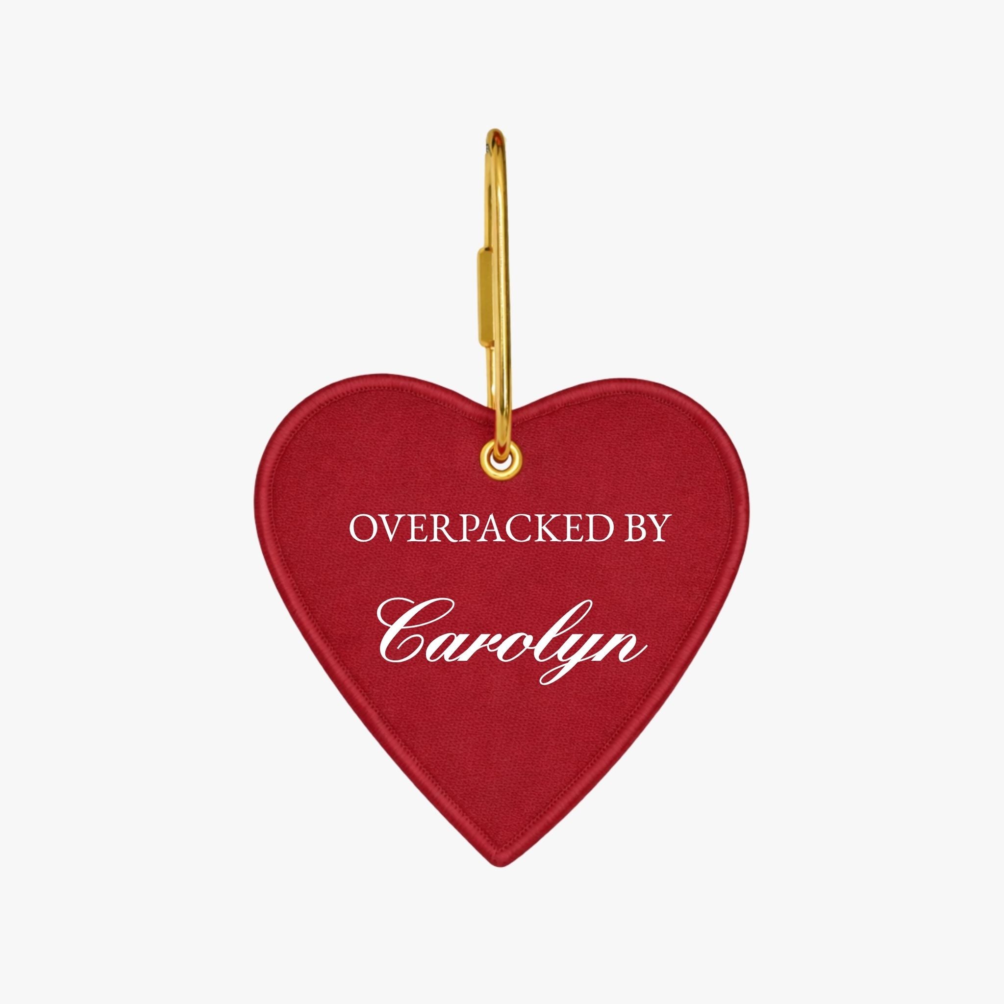 Red heart-shaped luggage tag with gold hook, personalized with 'Overpacked by Carolyn'.