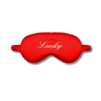 Red silk eye mask with 'Lucky' embroidery for restful sleep and relaxation.